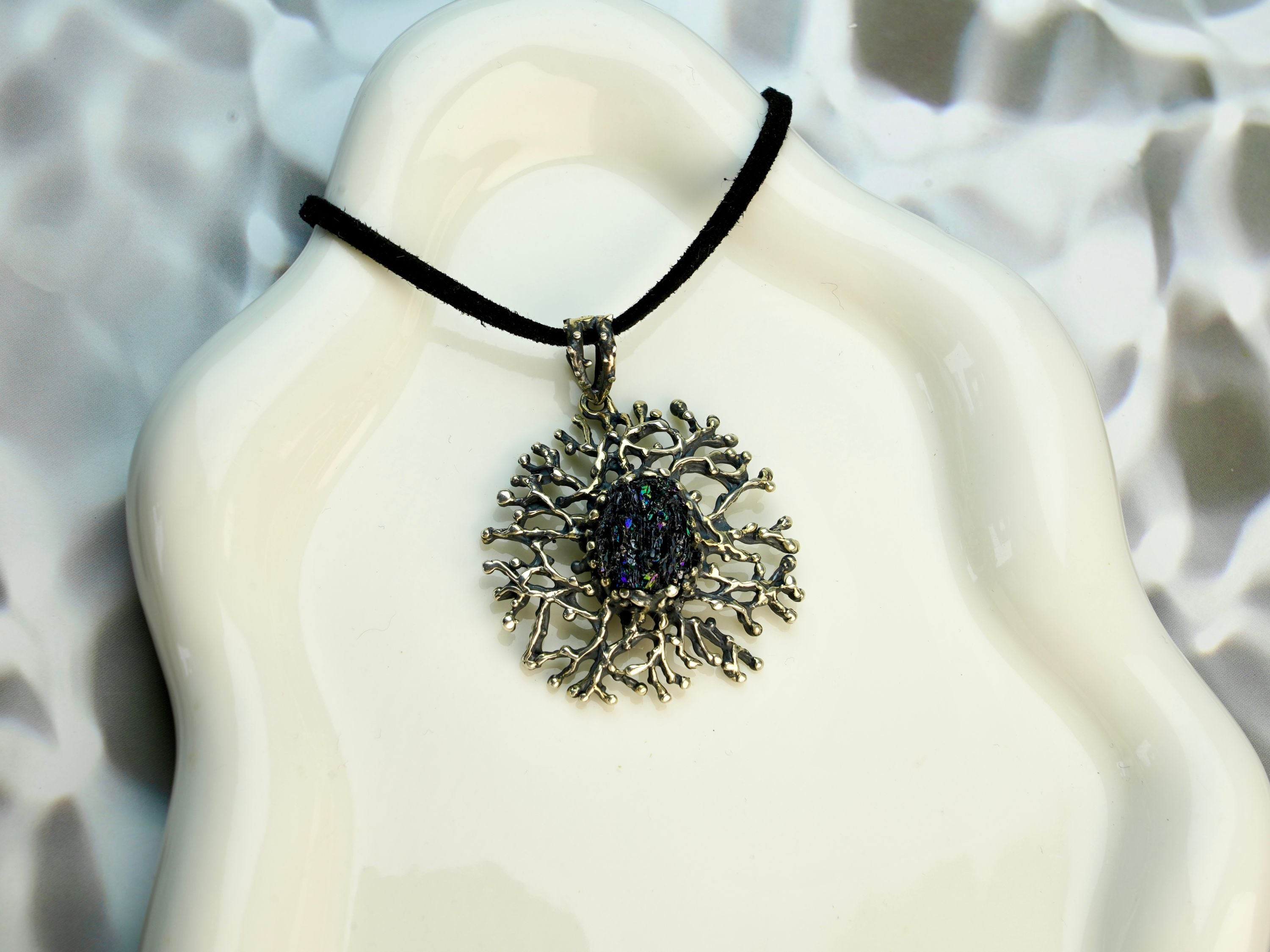 tourmaline pendant necklace on display, raw dark crystal sterling silver jewelry