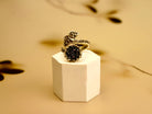 Black tourmaline ring adjustable sterling silver statement ring on pedestal minimal luxury background