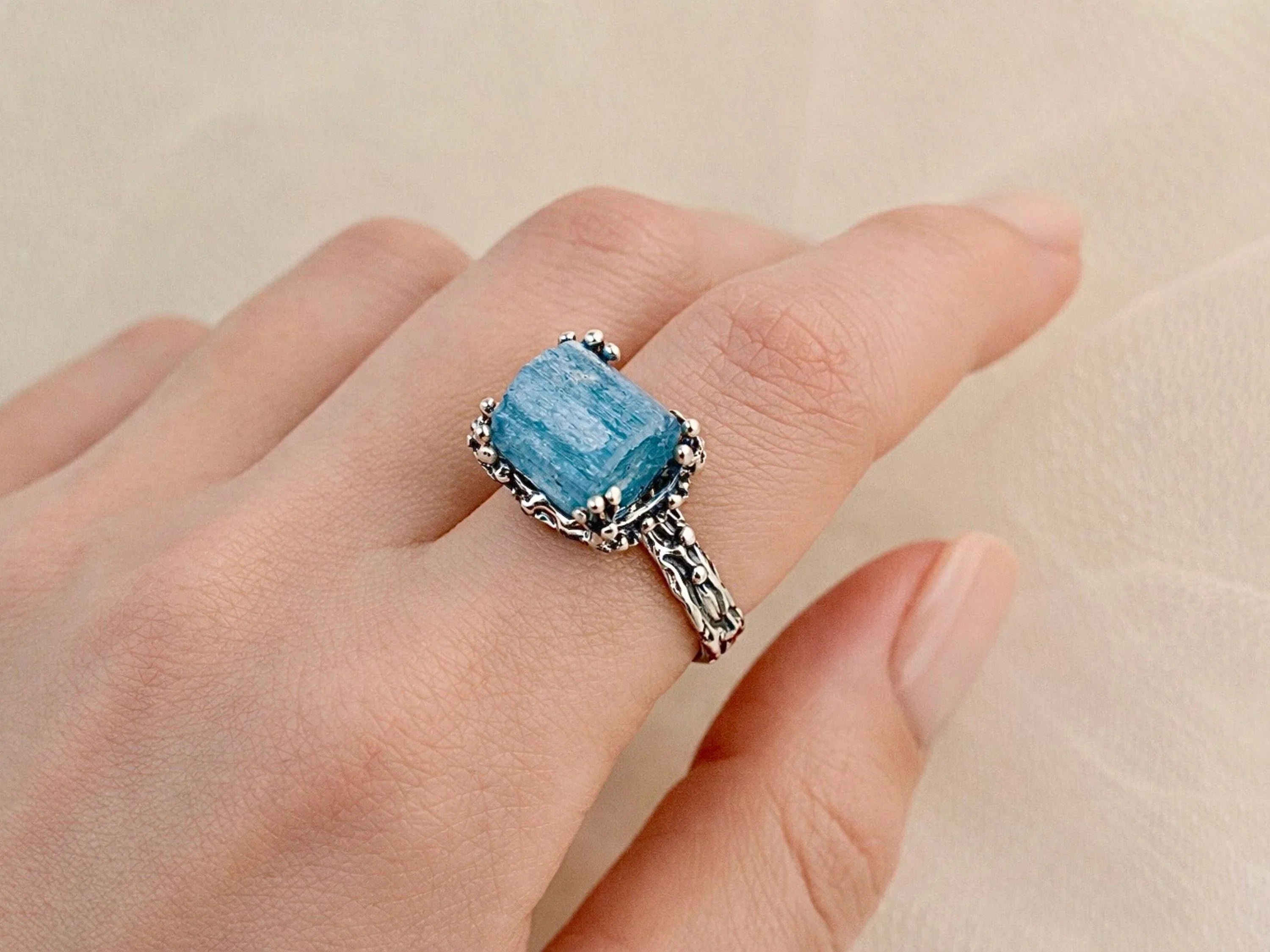 Aquamarine ring worn on hand adjustable sterling silver blue gemstone
