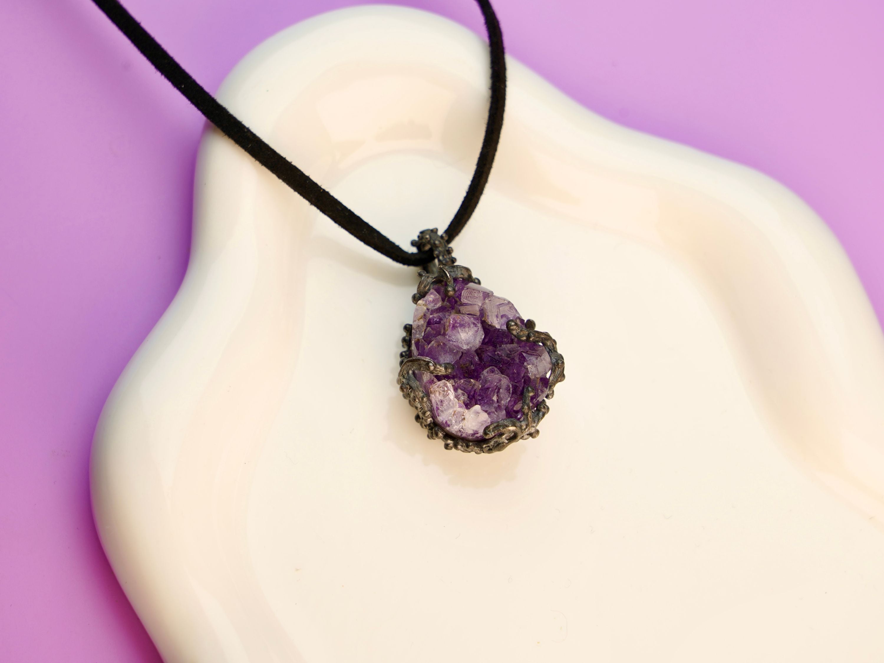 amethyst pendant necklace on display, raw purple crystal sterling silver jewelry