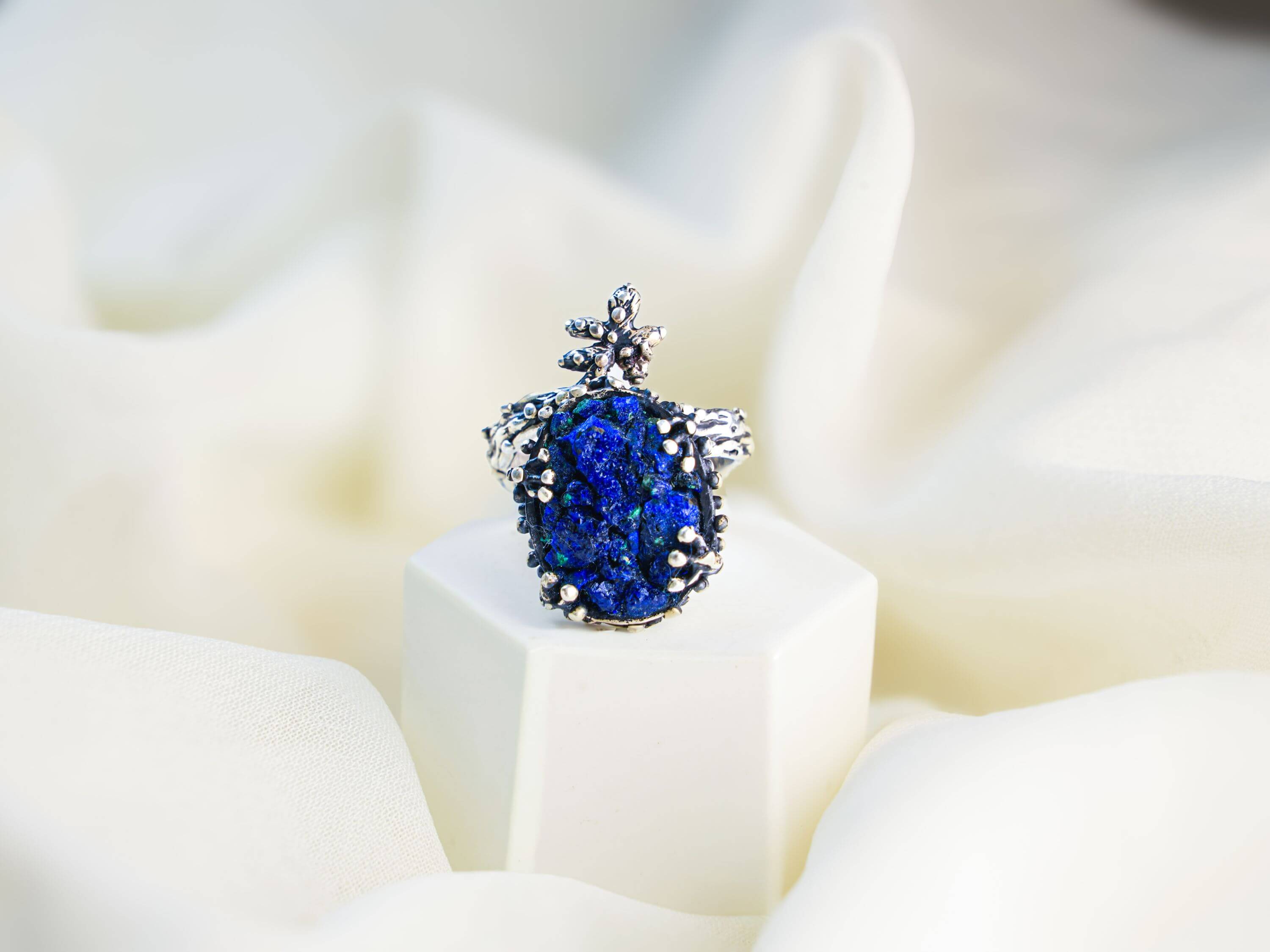 Macro shot of the natural lapis lazuli texture with golden pyrite flecks in a rustic silver setting