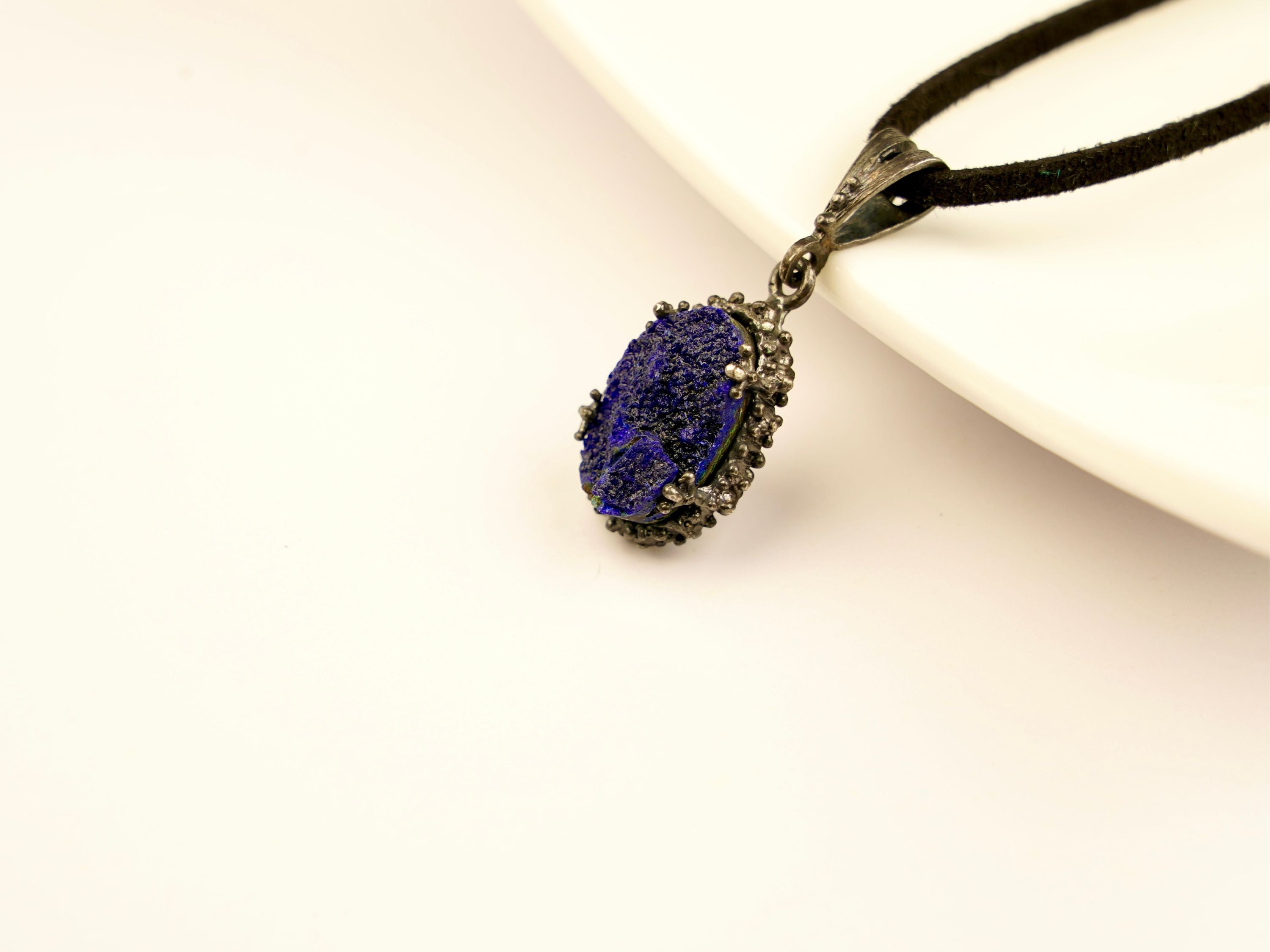 close up raw lapis lazuli pendant, natural blue stone texture detail