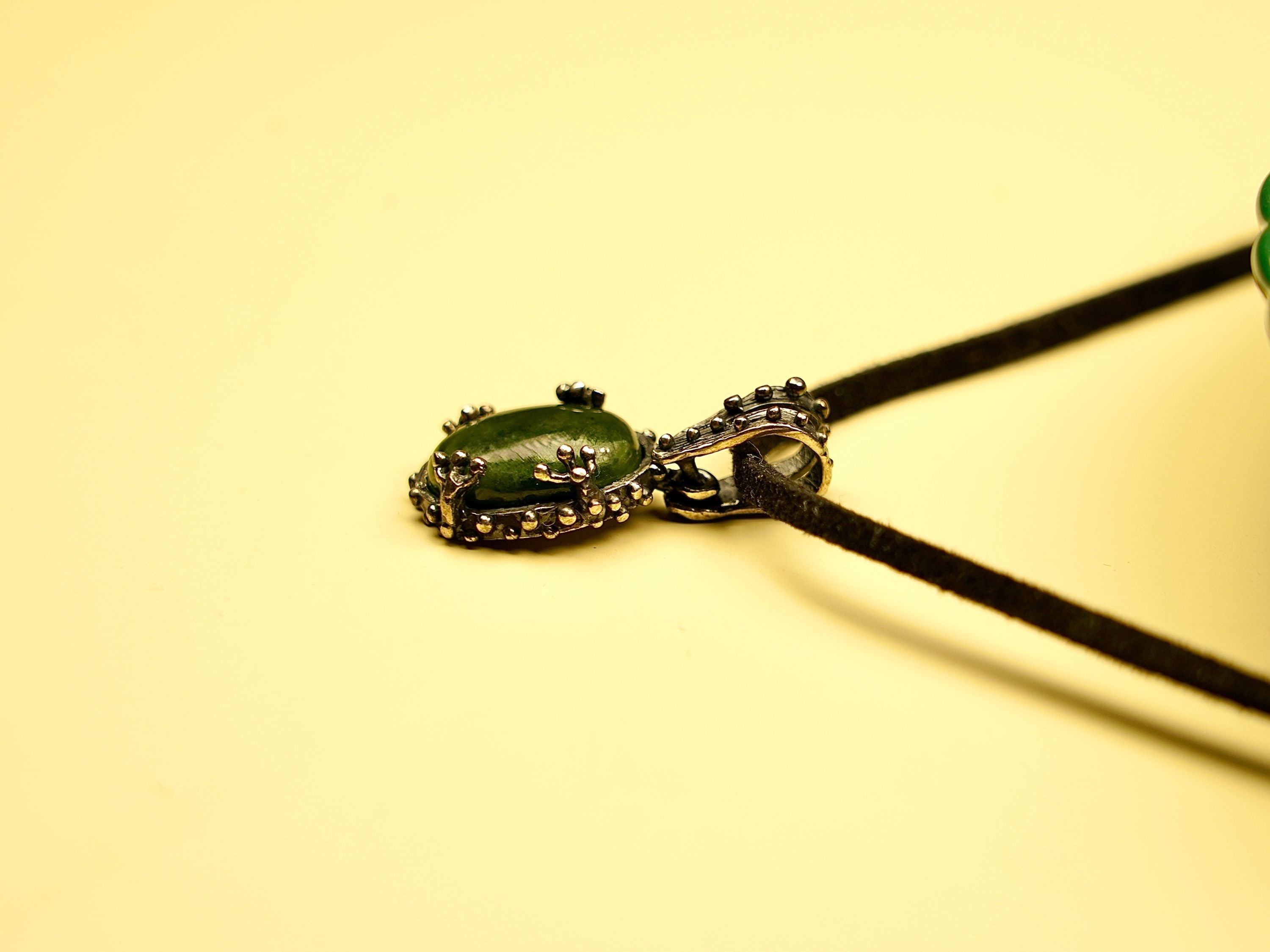 jade gemstone close up detail smooth green texture silver setting