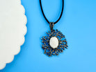 close up moonstone pendant, luminous stone and intricate silver structure