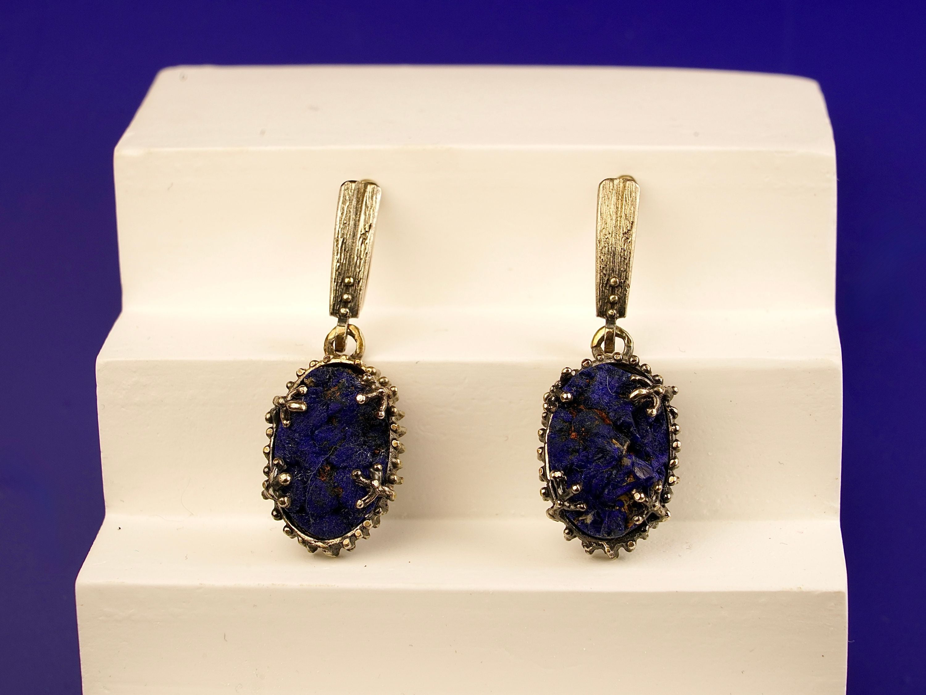 Close up lapis lazuli earrings deep blue textured stone detail silver setting