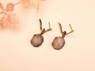 close up rose quartz earrings, soft pink gemstone glow detail