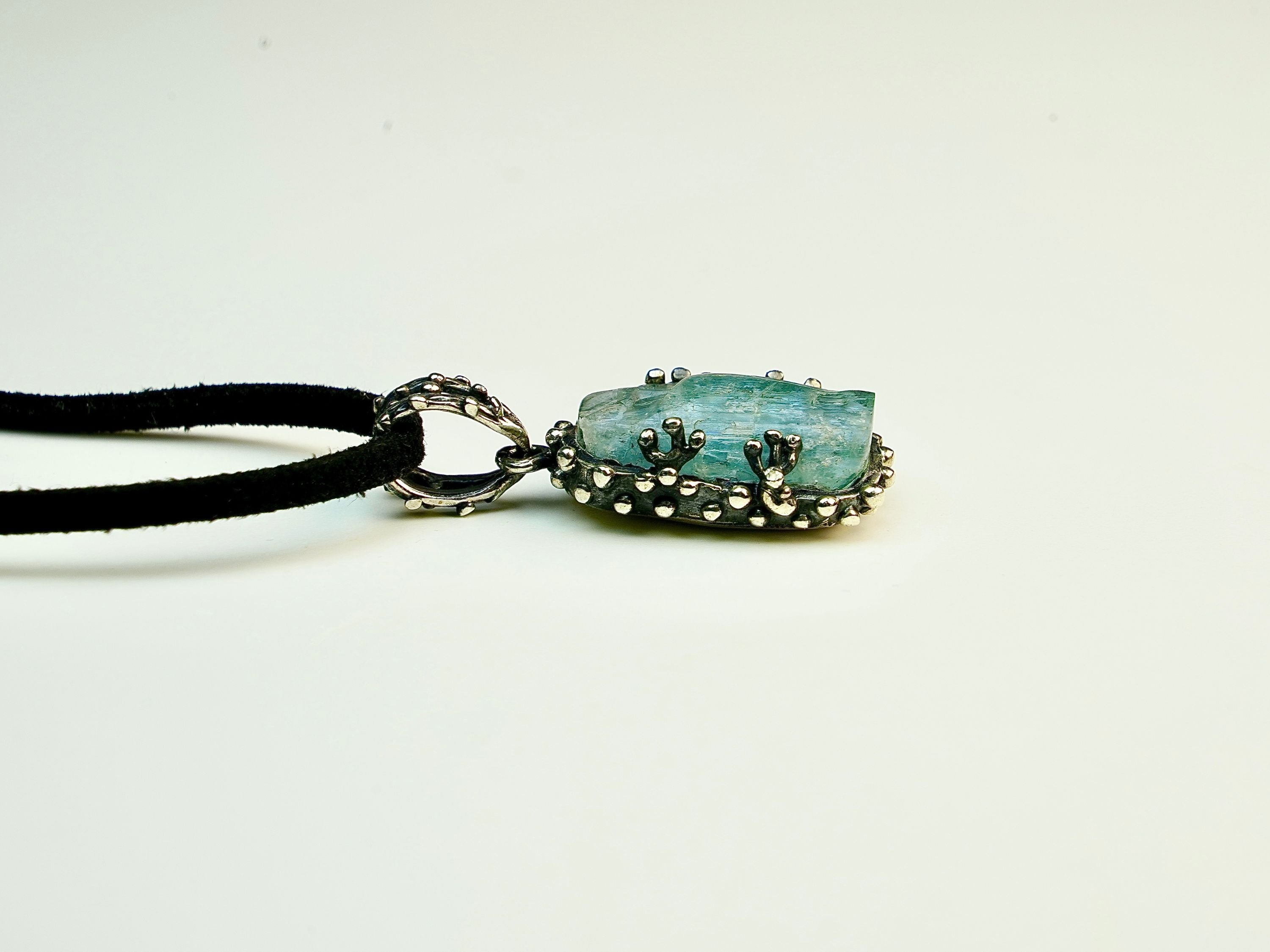 Close up aquamarine crystal raw texture blue gemstone detail sterling silver pendant