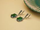 Close up jade earrings green gemstone texture detail silver setting