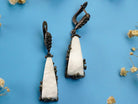 Close up moonstone earrings raw white crystal texture detail silver setting