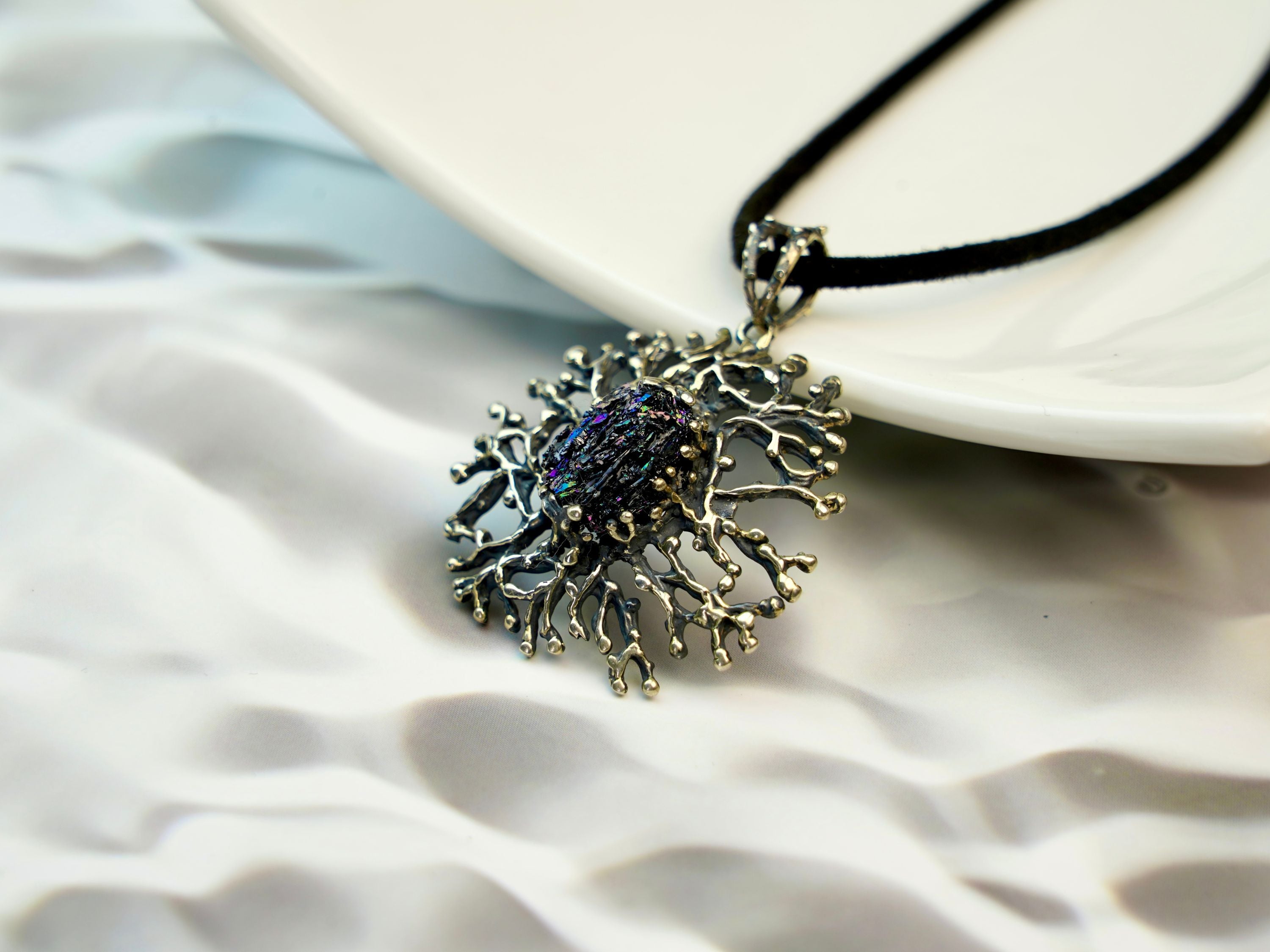close up raw tourmaline pendant, natural dark crystal texture detail