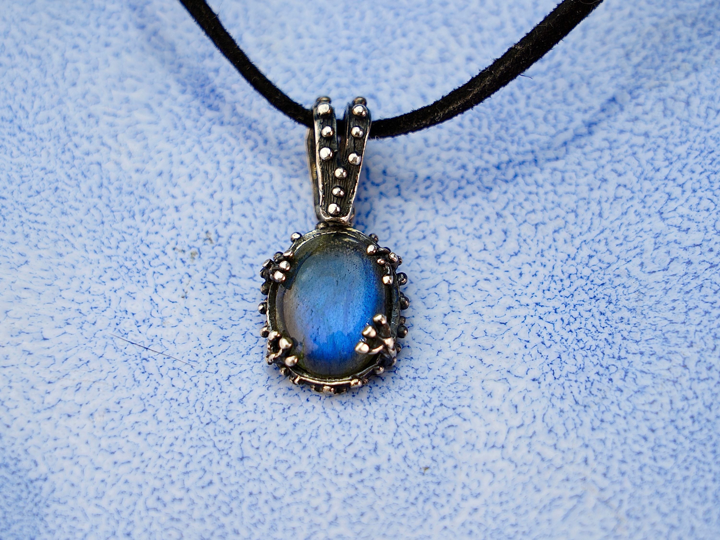 Close up labradorite pendant blue flash iridescent stone detail silver setting