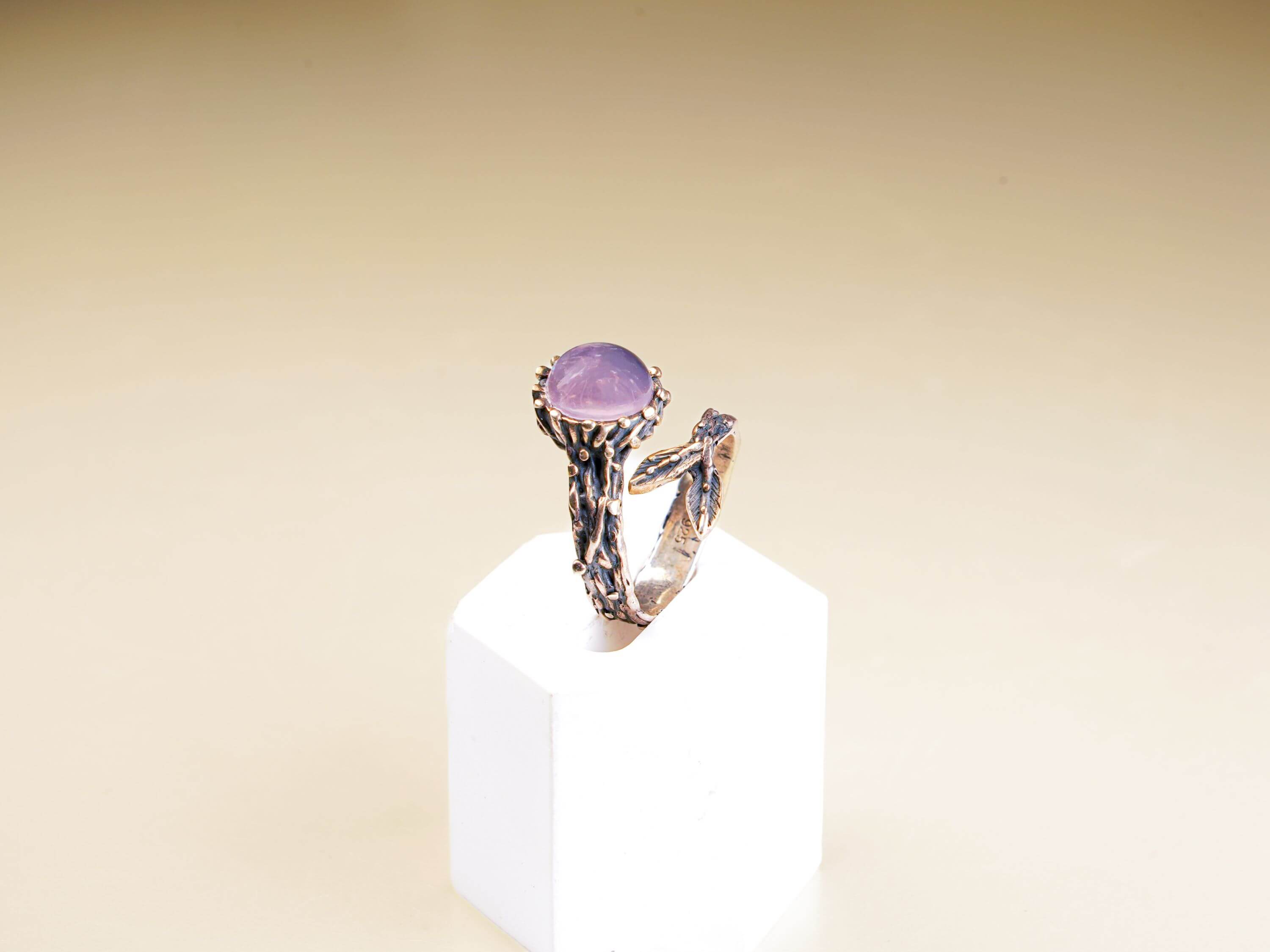Side profile of a botanical style rose quartz ring showcasing the detailed silver branch texture
