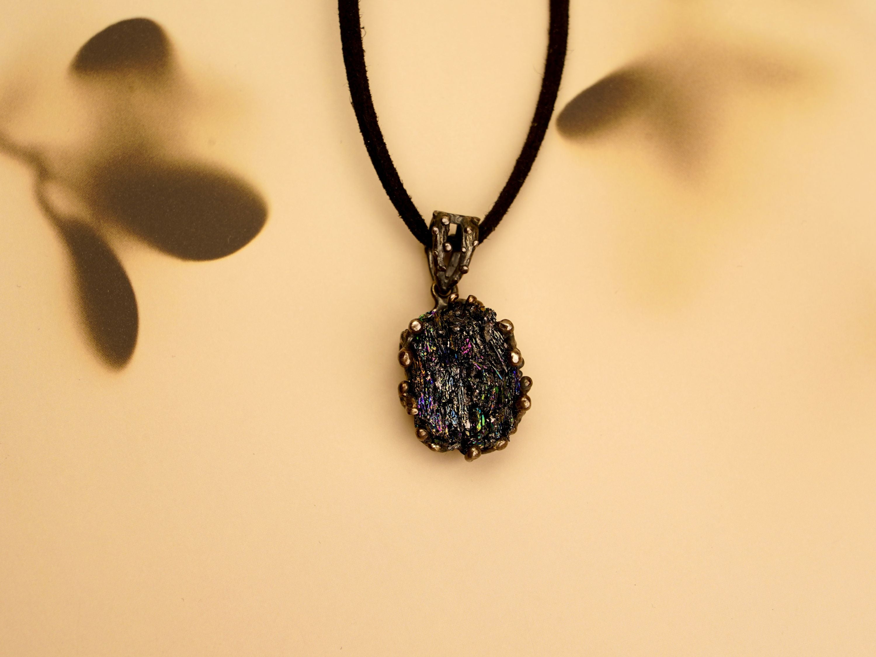 Detail shot of the Obsidian necklace on a textured stone surface, perfect for gothic and alternative fashion styles