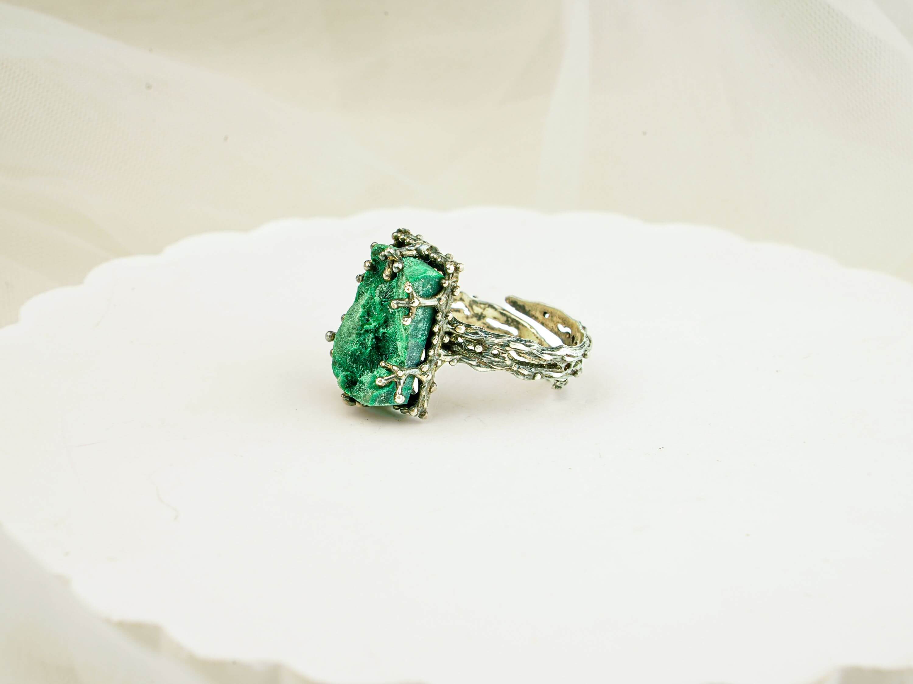 Side view of adjustable malachite ring showcasing the detailed vine-like silver craftsmanship