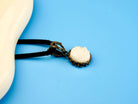moonstone pendant angled view, white gemstone elegant jewelry aesthetic
