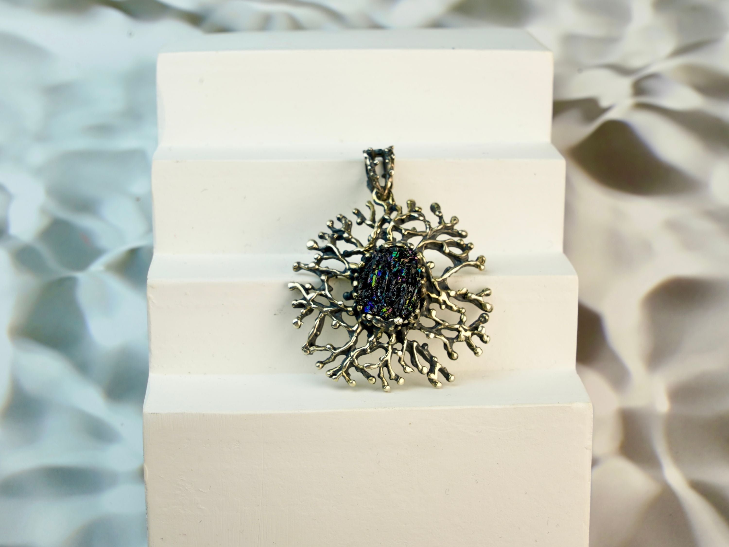 tourmaline pendant angled view, dark gemstone statement jewelry aesthetic