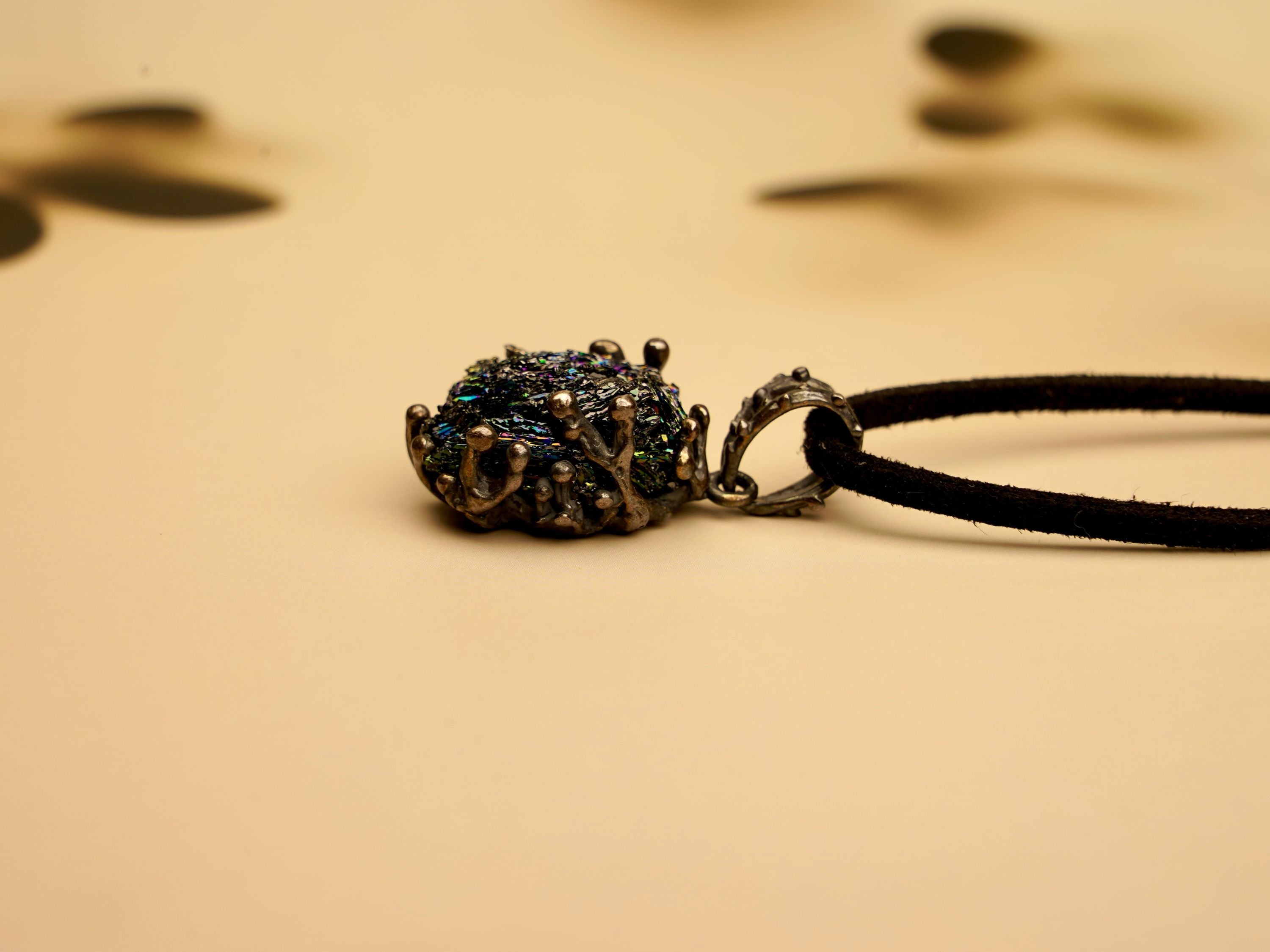 Macro photography of the gothic silver pendant's texture and the raw surface of the black Obsidian crystal
