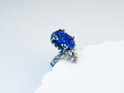 High-angle shot of the iridescent blue lapis lazuli ring on a branded Akra jewelry pouch