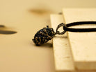 Minimalist artistic shot of the AKRA Obsidian necklace, highlighting its raw aesthetic and natural beauty