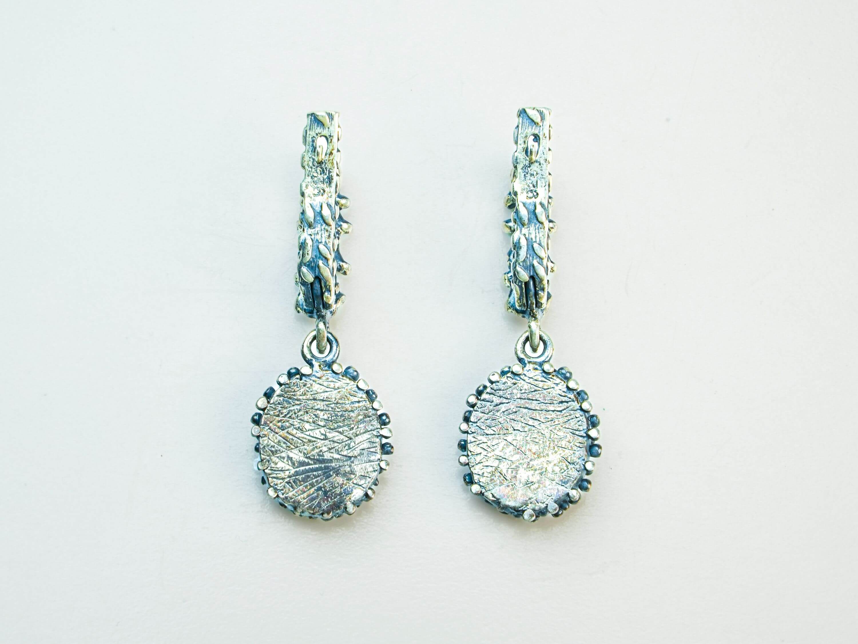 The reverse side of the Malachite earring, showing the hypoallergenic 925 sterling silver stamp, smooth silver setting, and secure ear wire closure