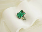 Artistic shot of a bold green malachite statement ring nestled in soft white fabric folds
