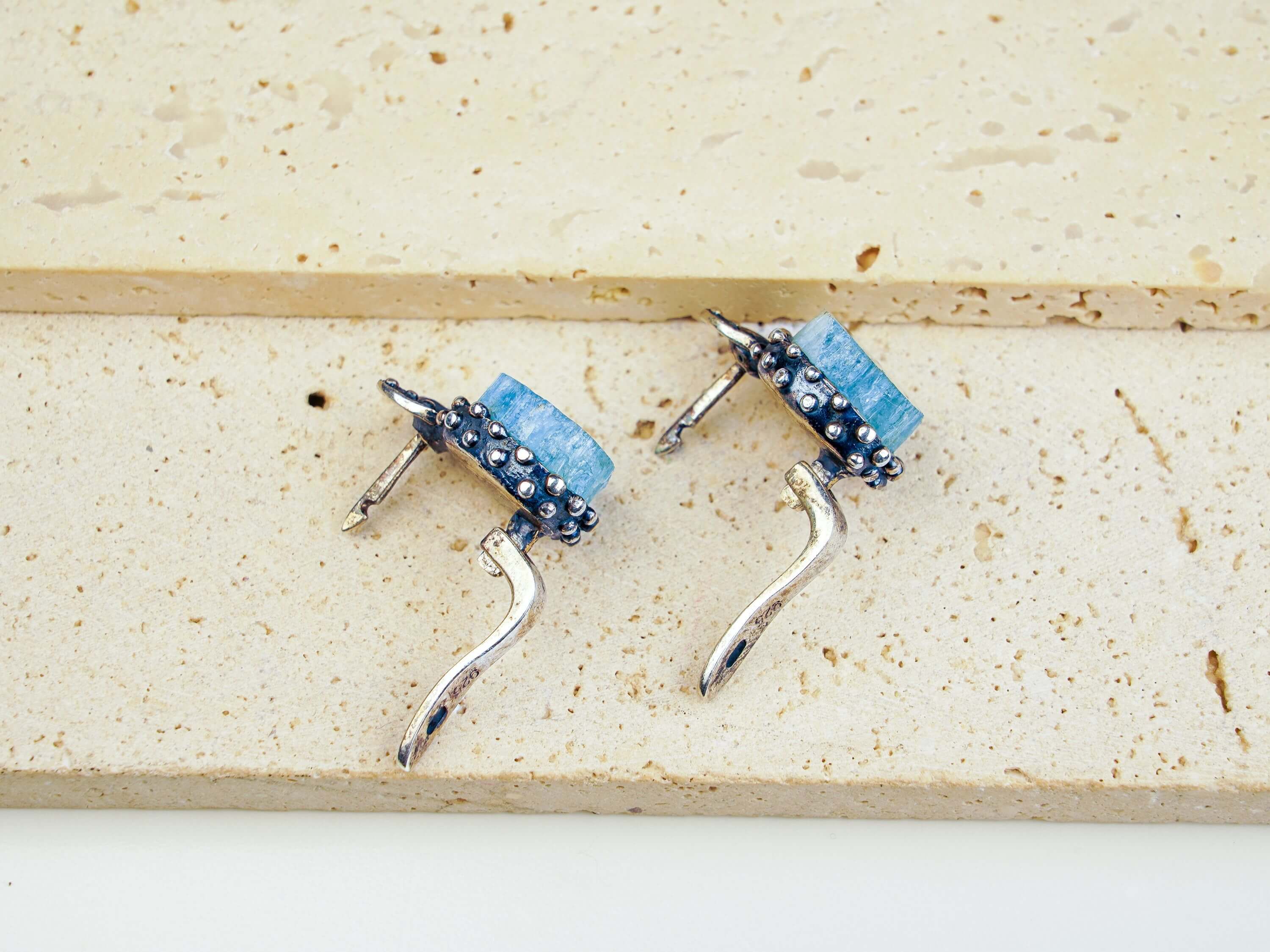 Top-down layout of the silver aquamarine earrings showing the open-back setting for light transparency