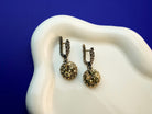 Lifestyle pyrite earrings metallic gold statement jewelry styled composition