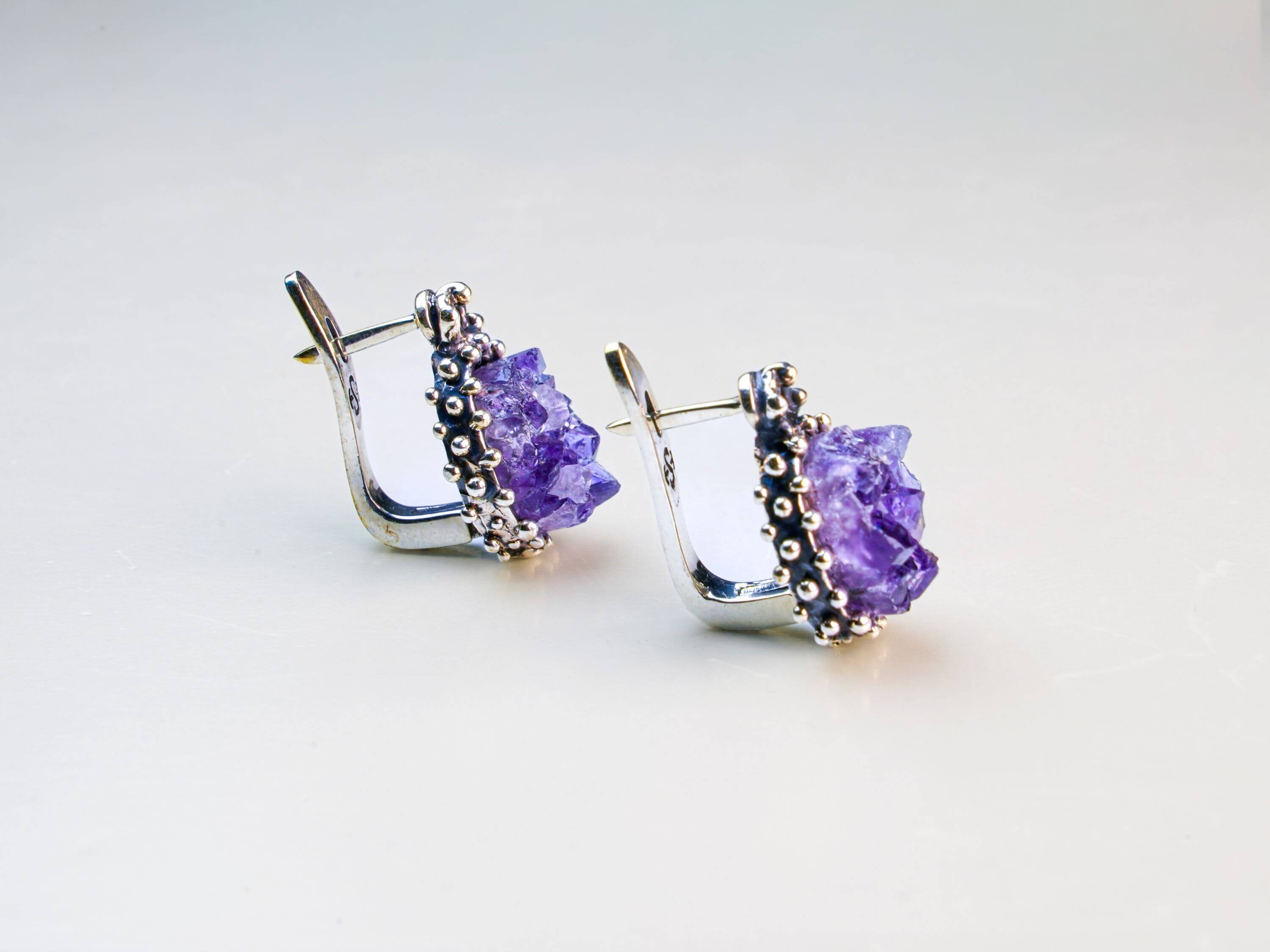 A pair of artisan amethyst earrings, showcasing unique natural stones handcrafted by Akra Gems in Tbilisi