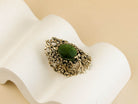 Top-down view of the handcrafted Jade ring, showcasing the complex and unique silver patterns surrounding the green gemstone.