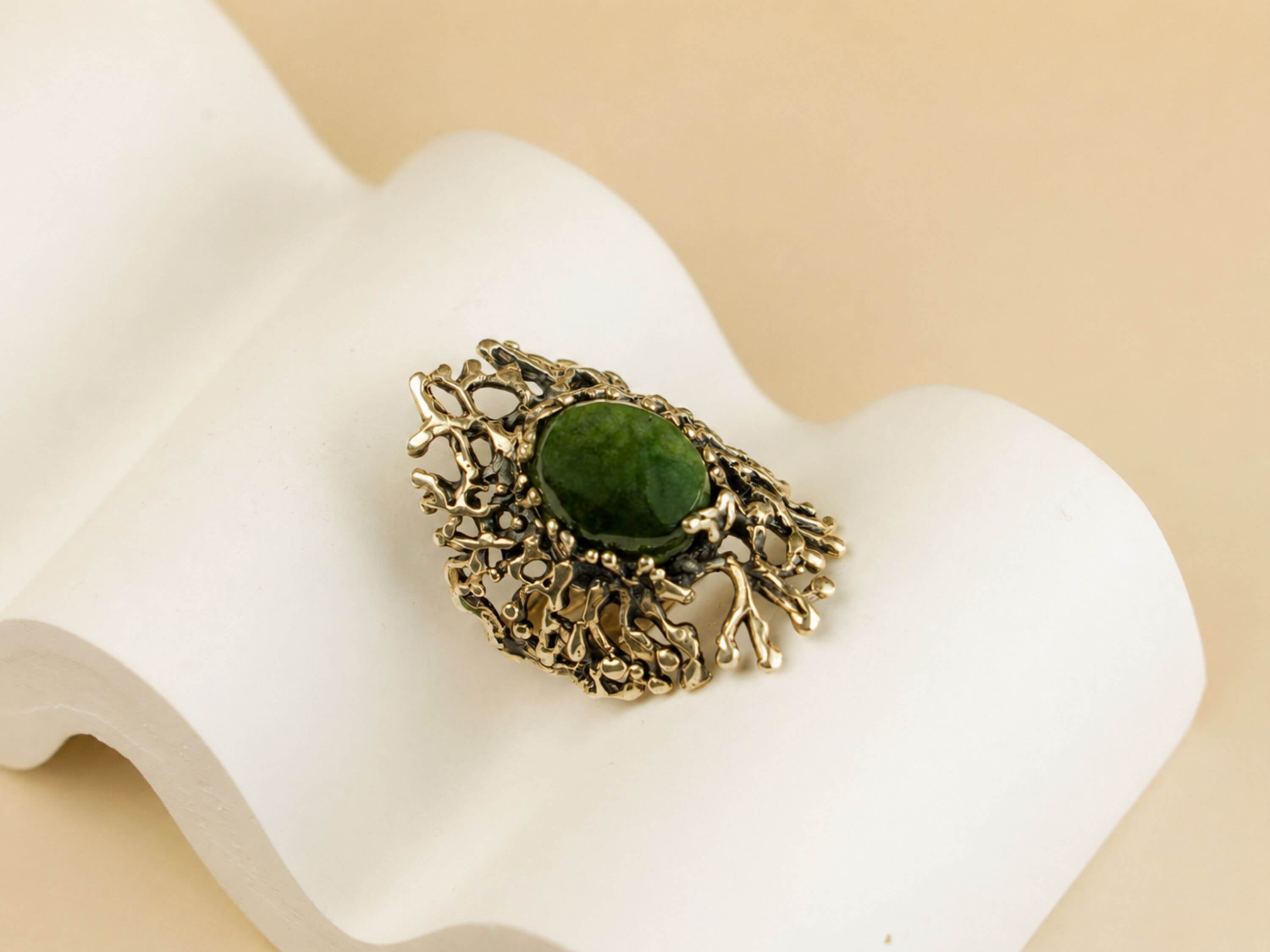 Top-down view of the handcrafted Jade ring, showcasing the complex and unique silver patterns surrounding the green gemstone.