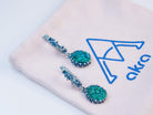 An aesthetic lifestyle image of the Malachite earrings paired with natural textures like linen and stone, showcasing an earthy, artisanal jewelry vibe
