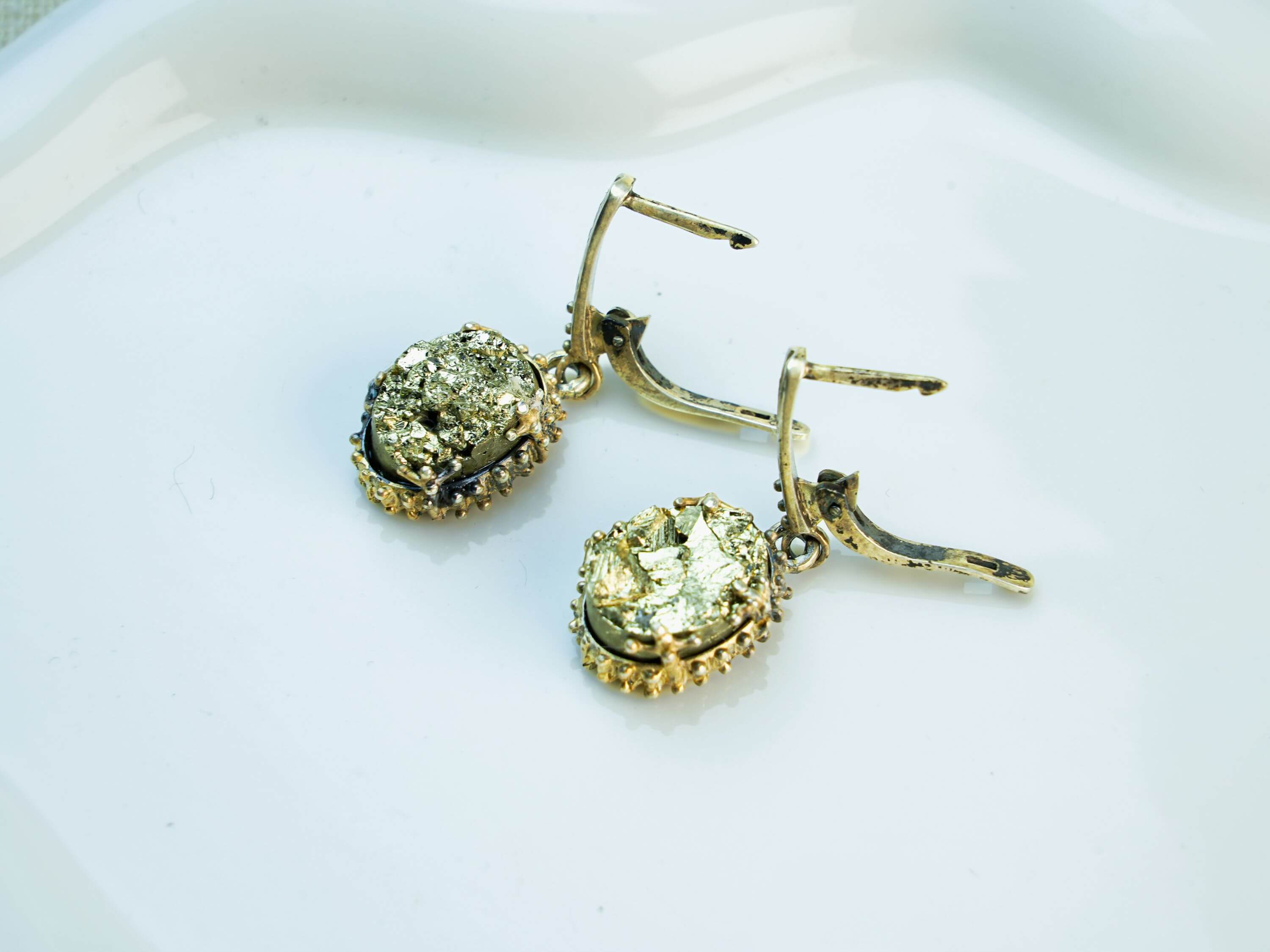 Handmade Akra Gems pyrite earrings, showcasing the unique beauty of natural metallic crystals crafted in Tbilisi