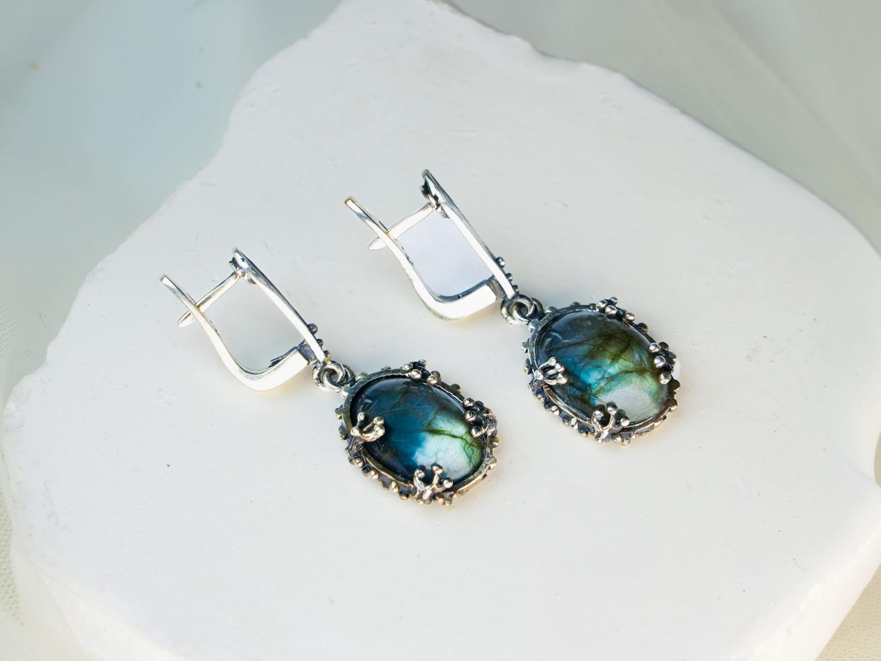 Front view of labradorite dangle earrings, showing the symmetrical design and silver craftsmanship