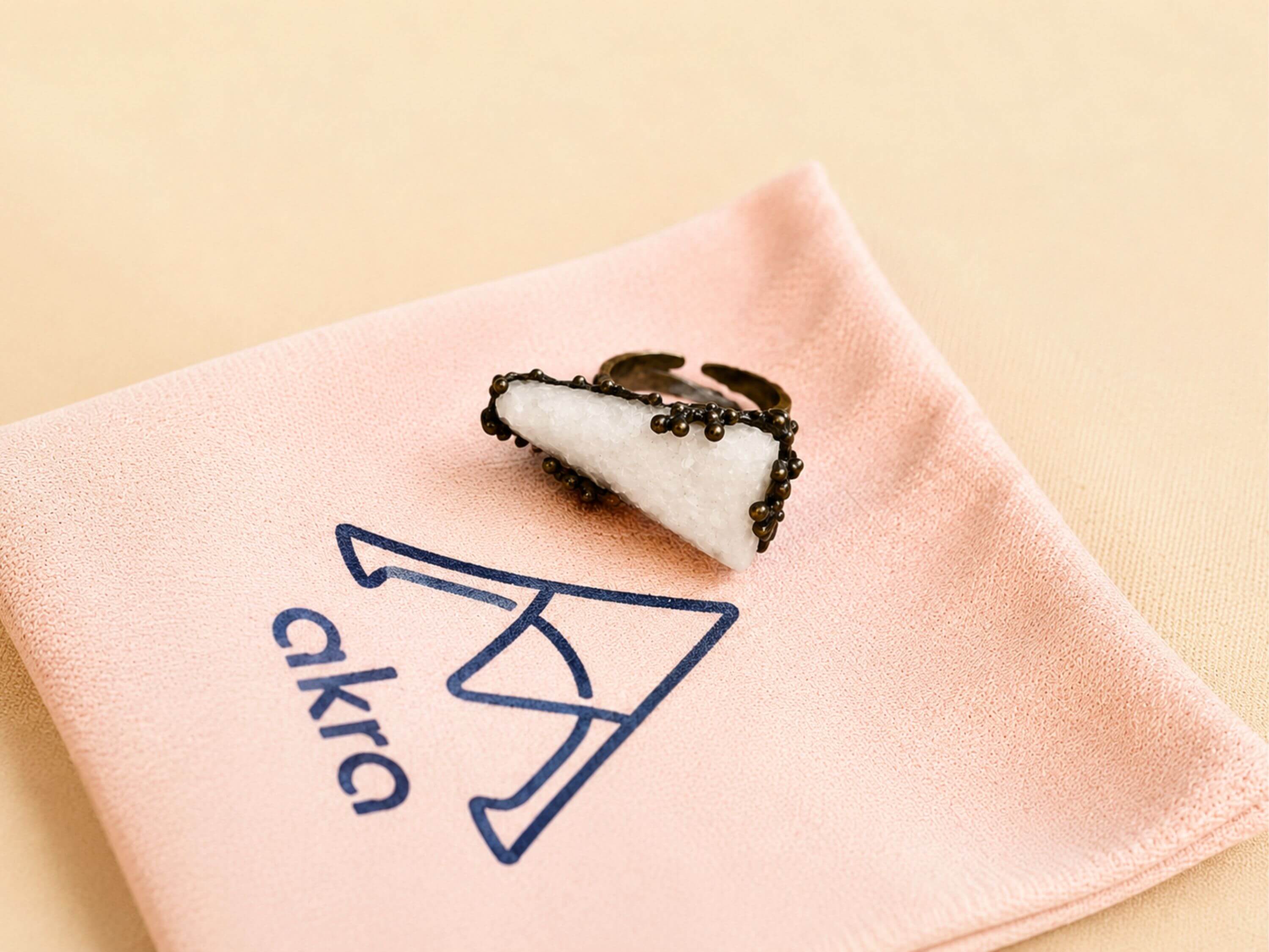 Artistic shot of the statement Moonstone ring resting on an Akra Gems branded pink jewelry pouch, capturing its boho-chic aesthetic.