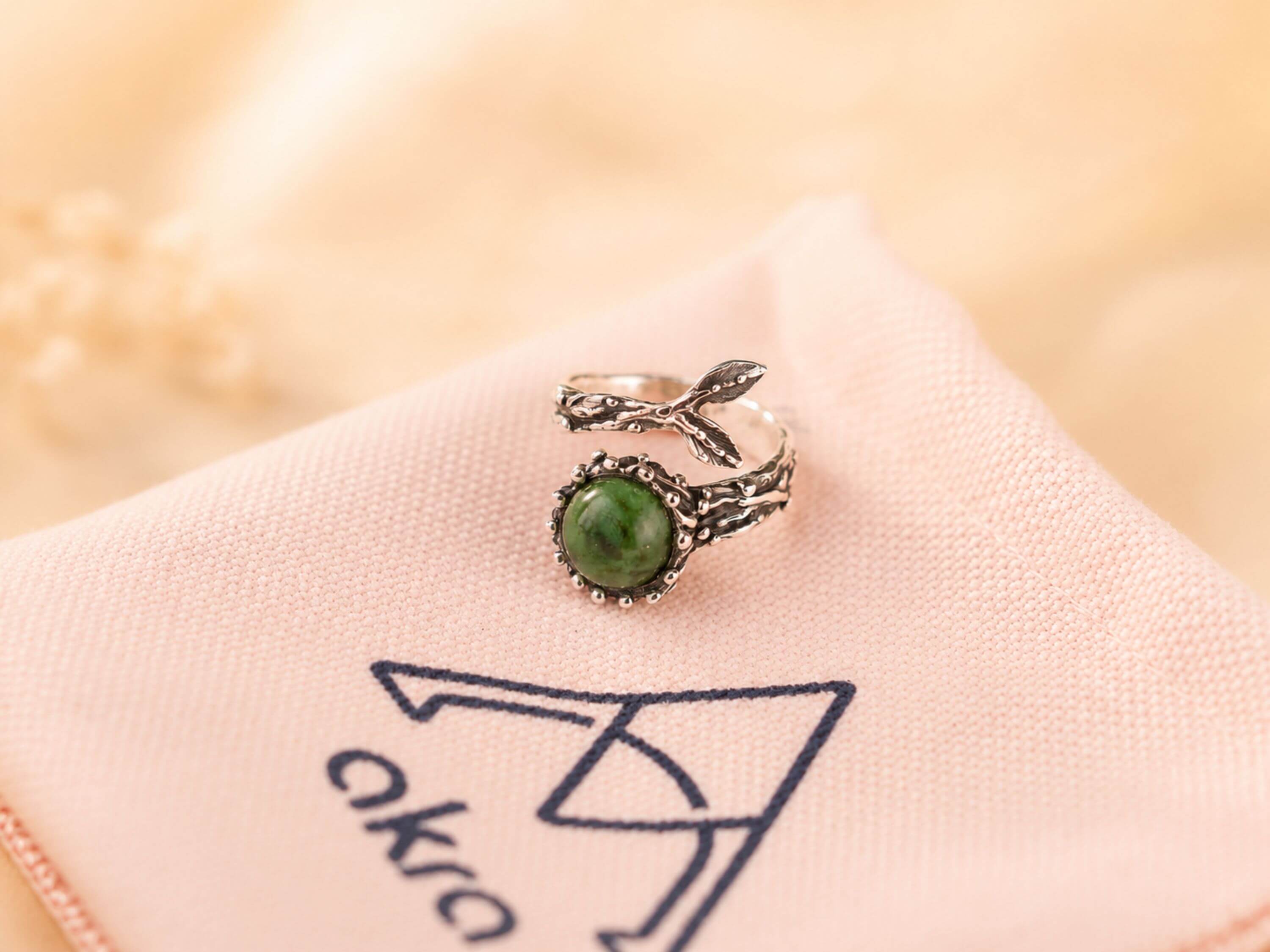 Mystical aesthetic shot of the raw green Jade ring, capturing its natural earthy energy and sophisticated handcrafted vibe.