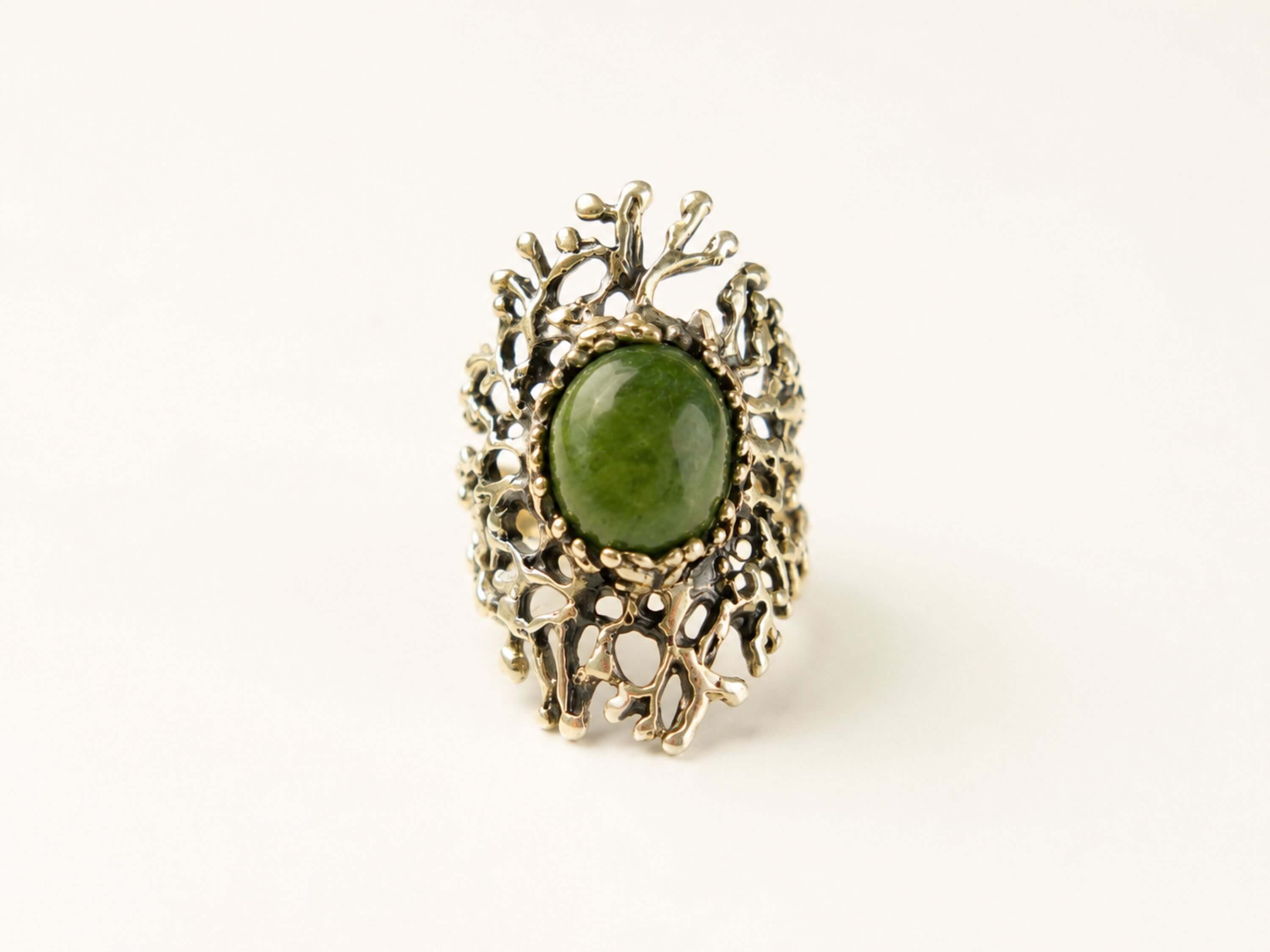 Direct front view of the green Jade ring, illustrating the symmetrical beauty of the stone and its powerful presence as a statement piece.
