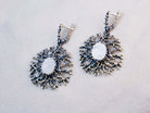 Statement Moonstone drop earrings featuring an intricate sterling silver branch design, showcased on a neutral background