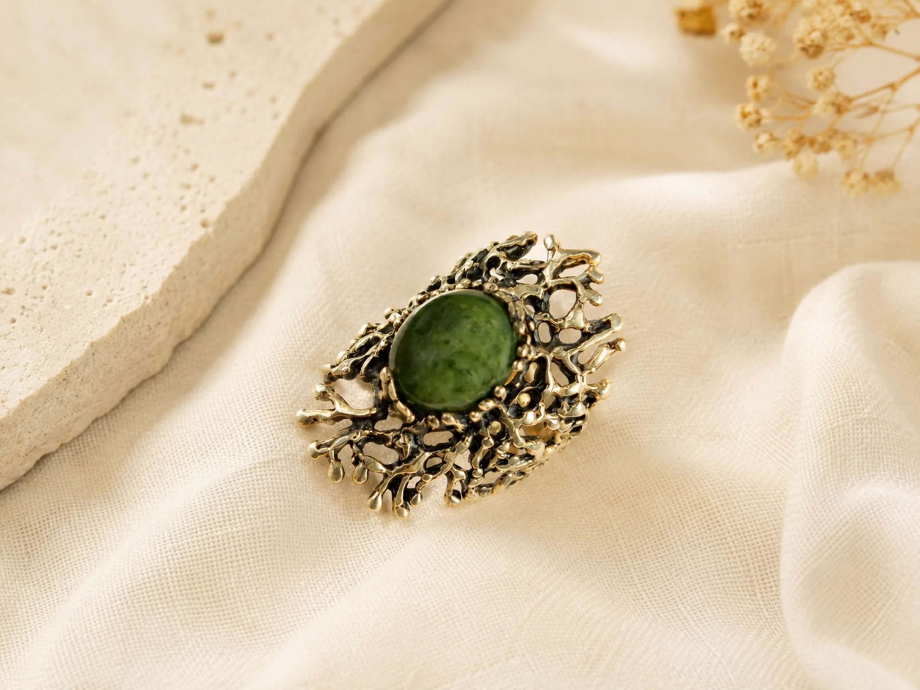 Top-down view of the handcrafted Jade ring, showcasing the complex and unique silver patterns surrounding the green gemstone.