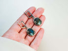 Labradorite drop earrings held in hand to demonstrate the actual size and scale of the gemstone