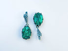 Direct front-facing view of the pear-shaped earrings, emphasizing the symmetry and the rich texture of the silver setting