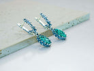 Handmade Akra Gems Malachite earrings resting alongside other pieces from the green gemstone collection, crafted in Tbilisi, Georgia