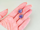 Handheld shot of both amethyst dangles, demonstrating the bold statement size and handcrafted silver frame