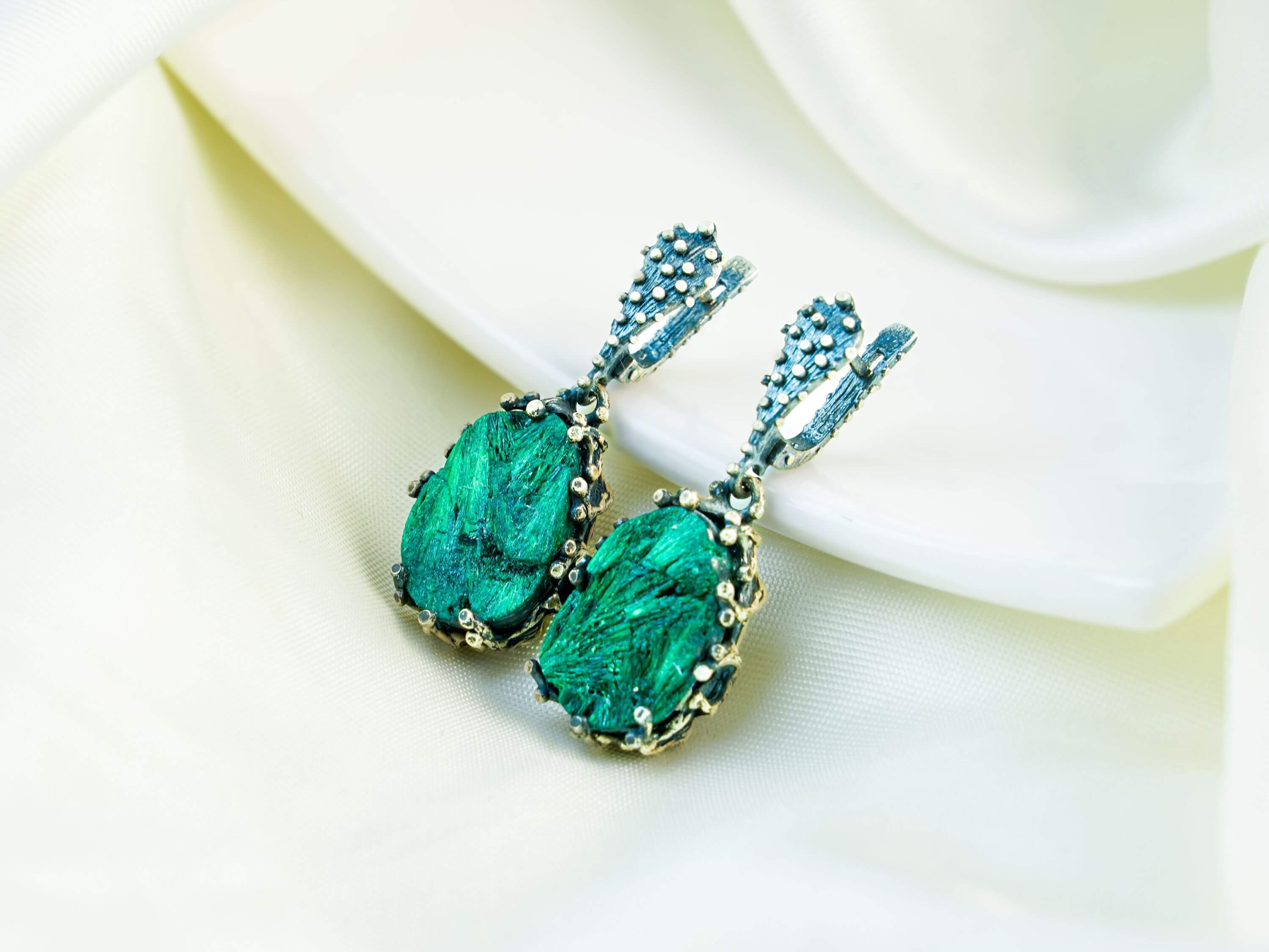 Teardrop Malachite earrings in a detailed sterling silver setting with unique green stone patterns, displayed on a clean background