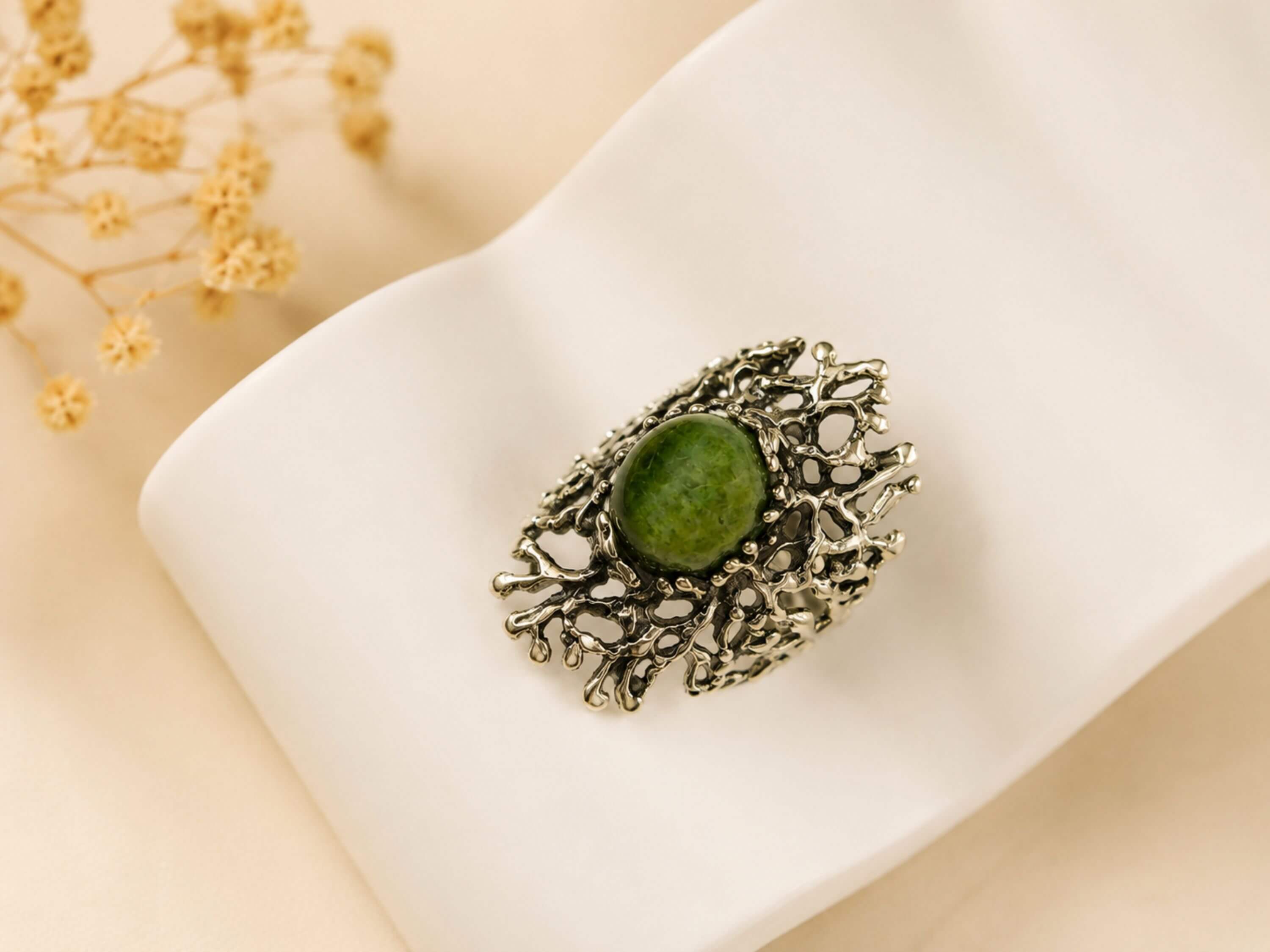 Close-up shot of the natural green Jade stone, highlighting the polished surface and the unique, branch-like sterling silver metalwork.