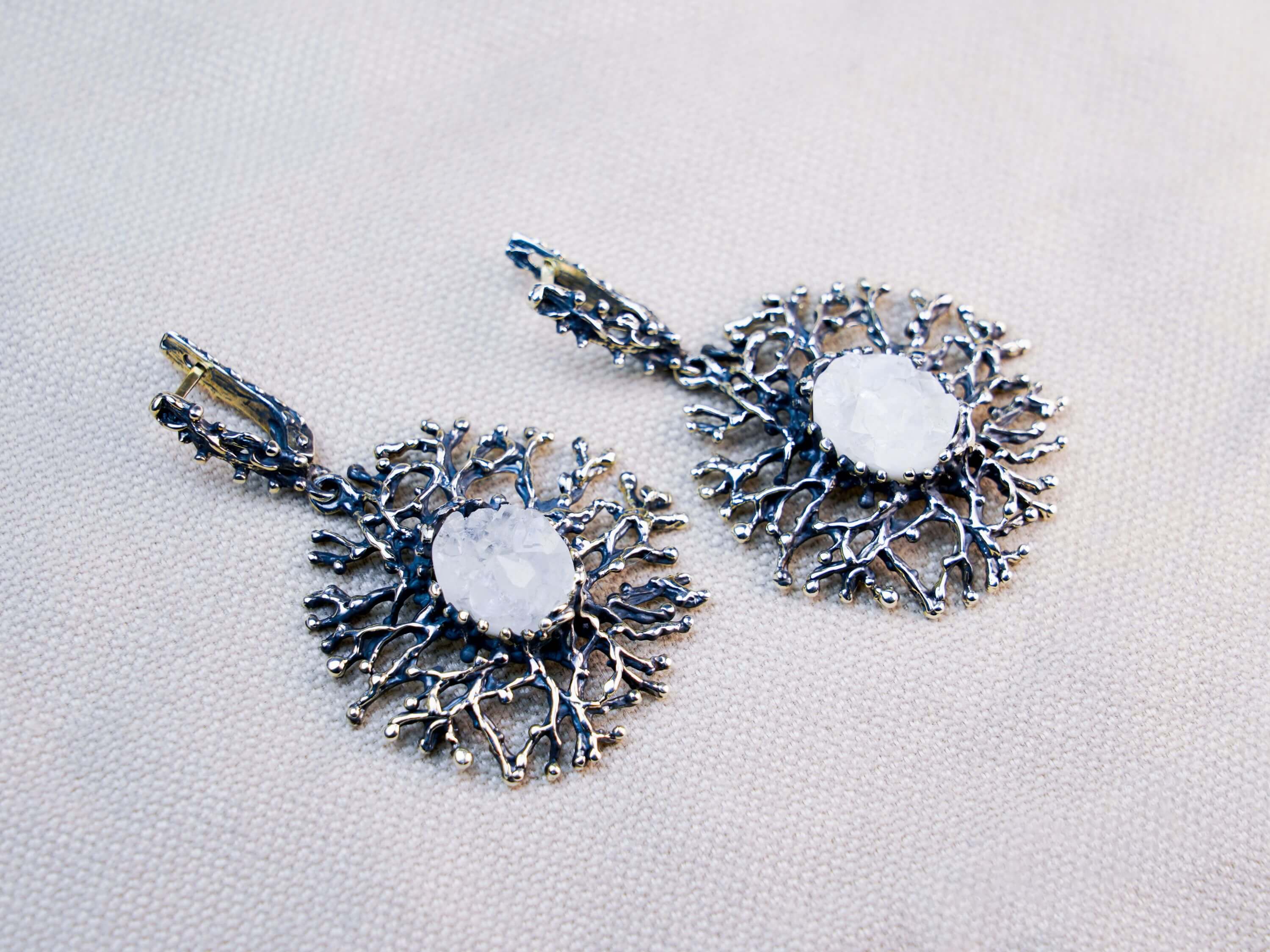 Macro shot of a natural white Moonstone with an ethereal blue glow, nestled in a handcrafted oxidized silver branch setting