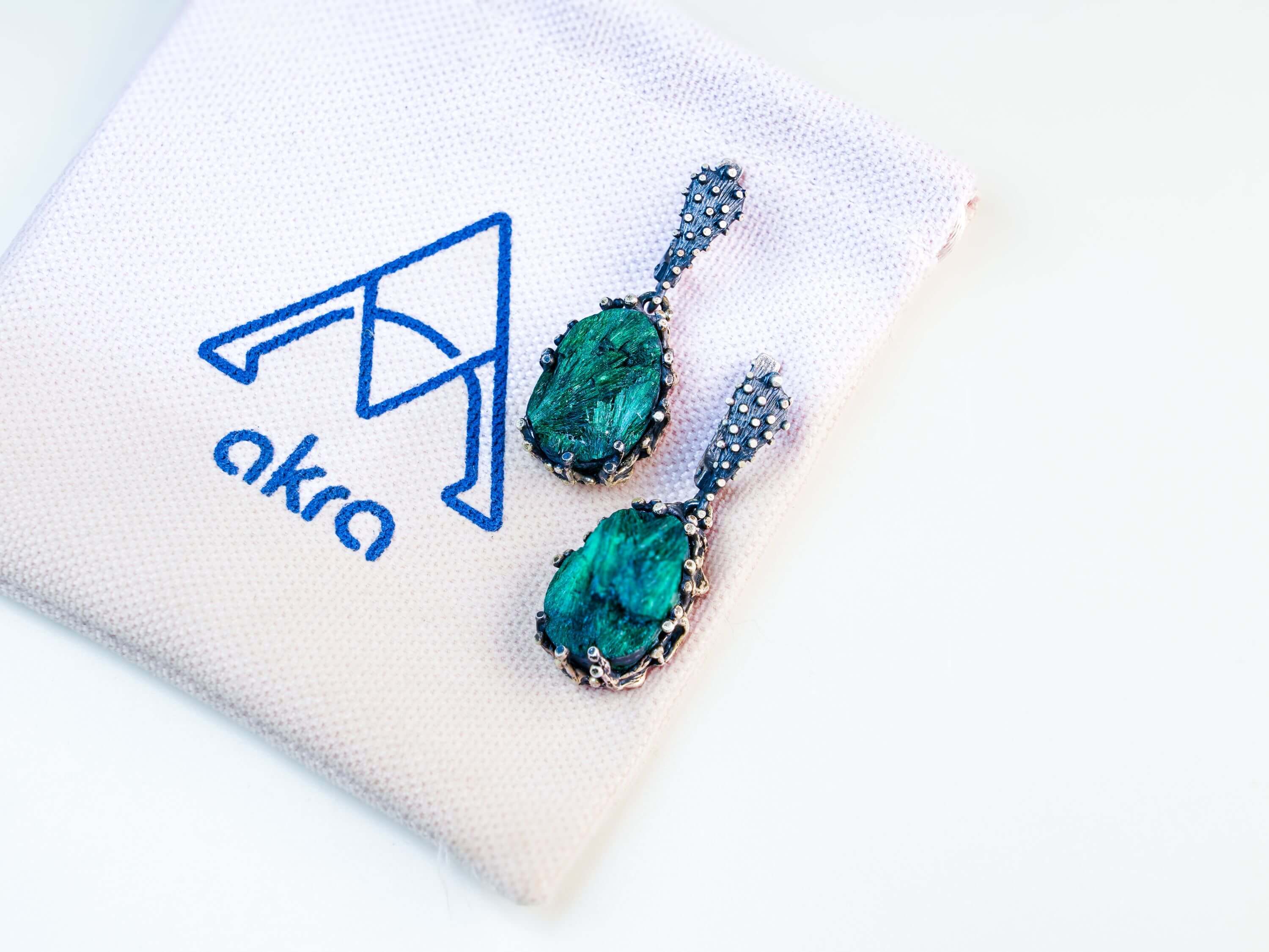 Artistic lifestyle shot of green malachite jewelry, capturing its earthy and sophisticated nature-inspired aesthetic