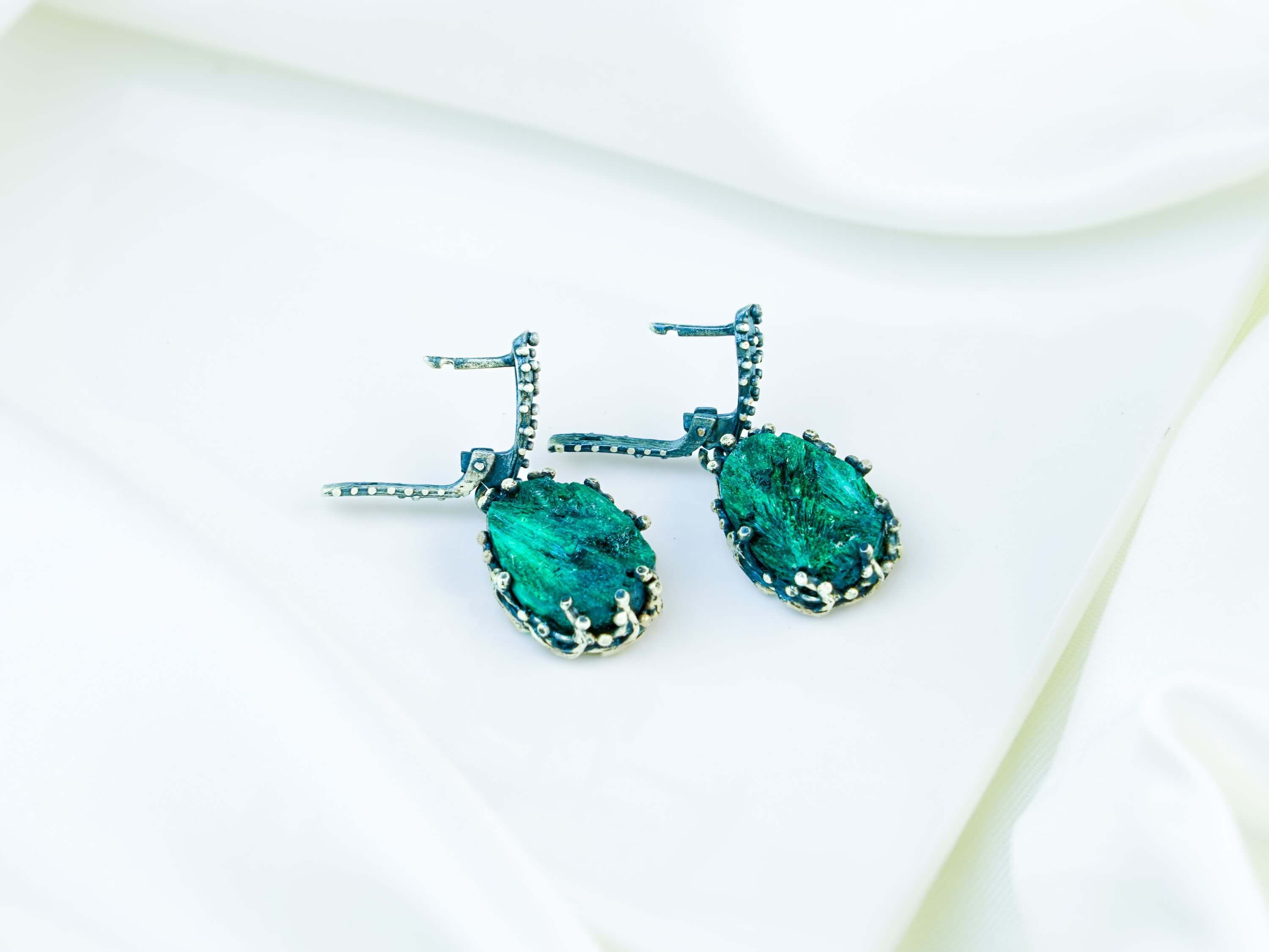 Side profile of the teardrop dangles, showing the depth of the stone and the intricate 'claw' design of the silver