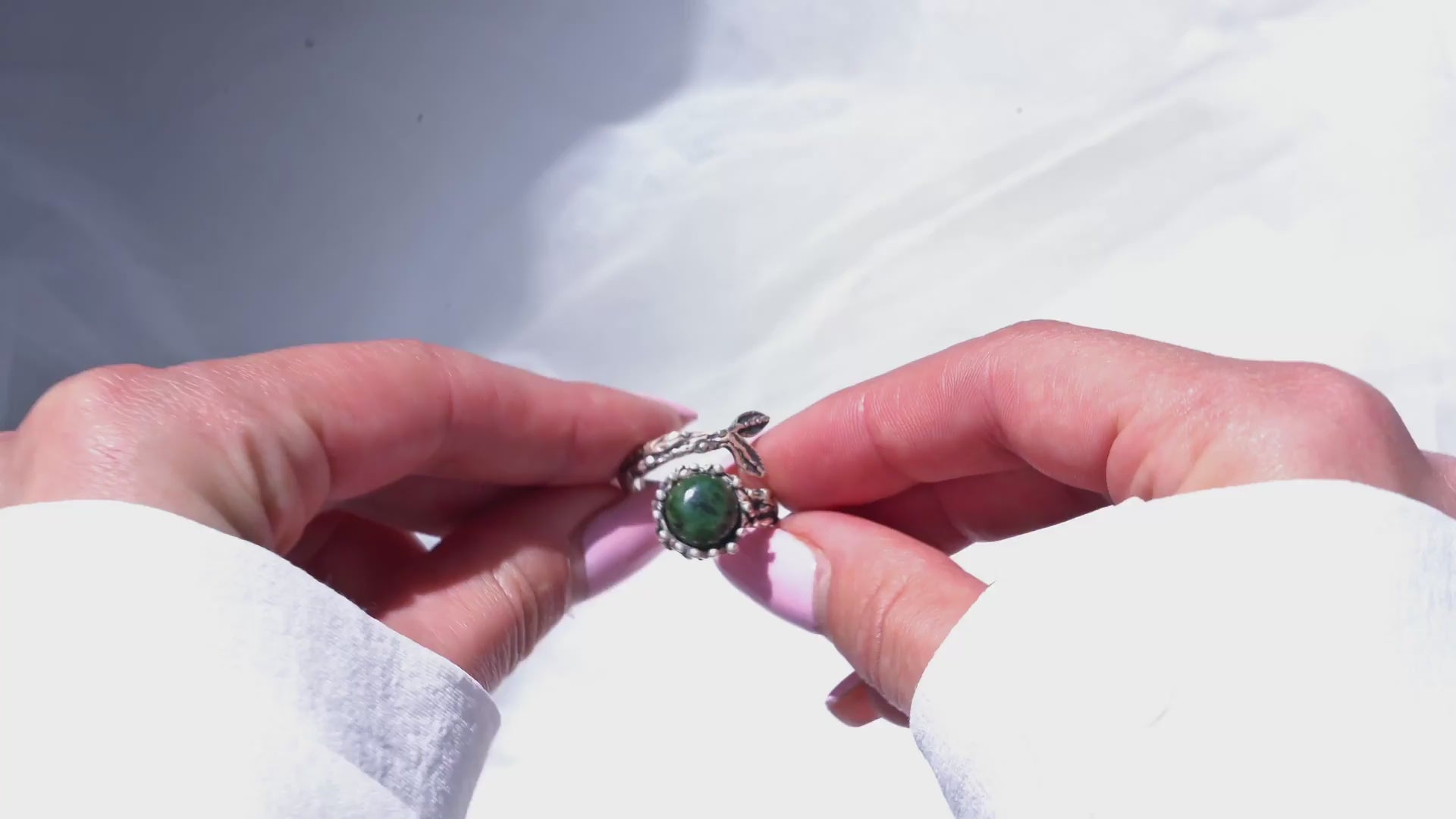 360-degree product video showcasing the raw green Jade gemstone and the intricate sterling silver branch design of the adjustable statement ring as it catches the light.