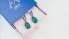 Video tour of teardrop malachite earrings, showing the 360-degree detail of the silver frame and the natural light reflecting off the green stone patterns