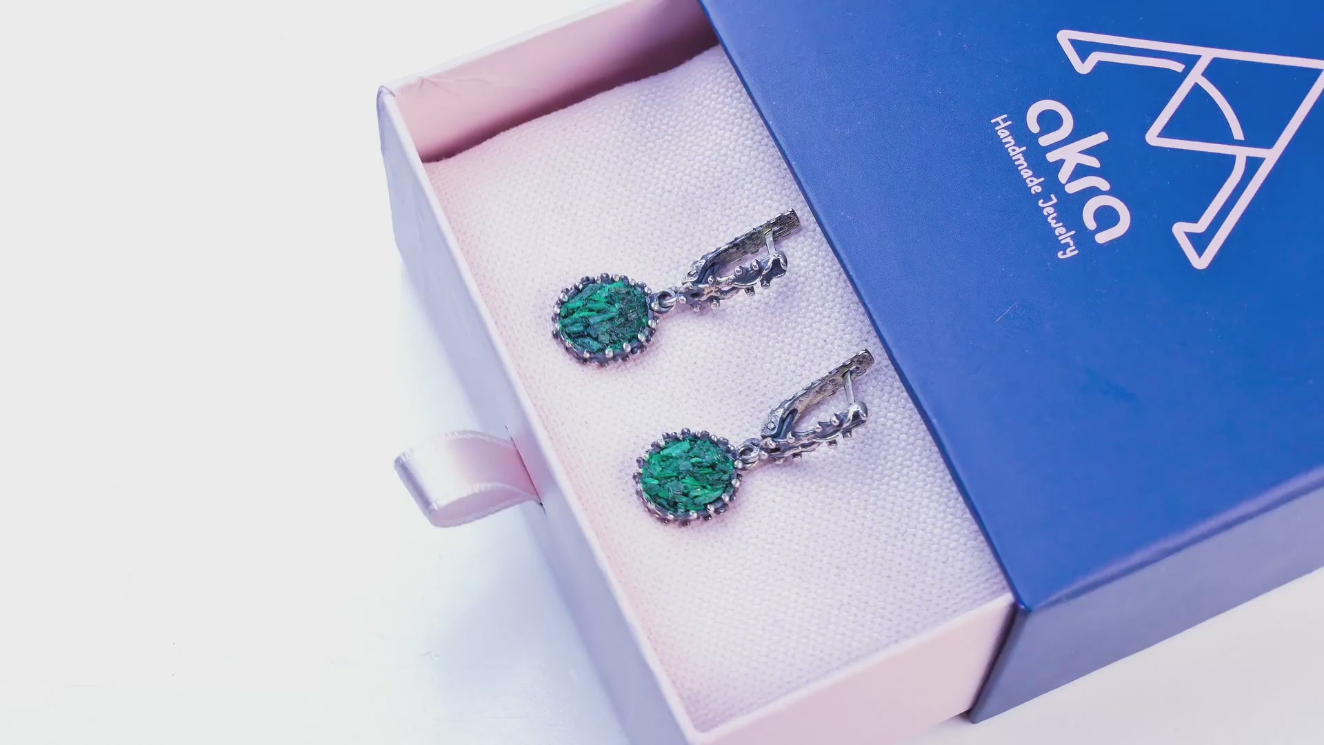 Video tour of handcrafted Malachite oval earrings, showing the 360-degree view, the movement of the dangles, the unique stone patterns in daylight, and the detailed sterling silver setting